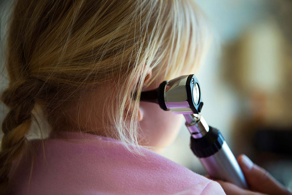 Arzt hört Oht bei Kind ab